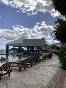 una fila de bancos de madera junto a una piscina en BeachAccess HotelZone 3705, en Cancún