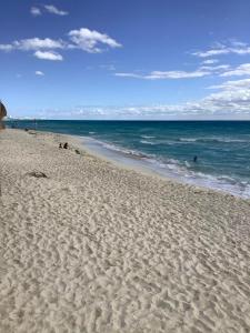 una spiaggia sabbiosa con persone che nuotano nell'oceano di BeachAccess HotelZone 3705 a Cancún