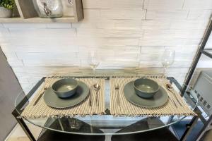 a glass table with two bowls and two wine glasses at Apartmán Strieborná v centre mesta in Banská Bystrica +3 photos
