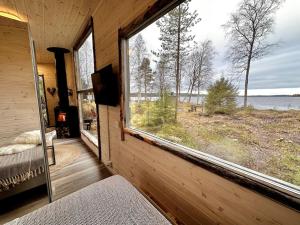 a room with a large window with a view of the water at Unique Cabin with Breathtaking Northern Light View in Rovaniemi