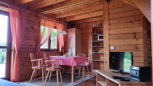 ein Esszimmer mit einem Tisch und Stühlen sowie einem TV in der Unterkunft Ferienhaus Bliev-Hee Nr 1 in Klink