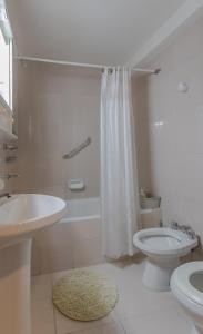 a white bathroom with a sink and a toilet at Alojamiento Belgrano in San Carlos de Bariloche