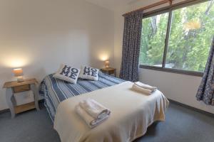 a bedroom with a bed with two towels on it at Alojamiento Belgrano in San Carlos de Bariloche