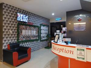 a store with a red chair and a reception counter at Pz Hotel in Kuala Kangsar