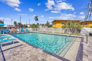 a swimming pool with blue chairs and a fence at Madeira Del Mar 305 in St. Pete Beach