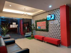 a waiting room with red benches and a tv at Pz Hotel in Kuala Kangsar