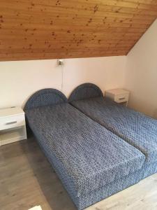 a bed in a bedroom with a wooden ceiling at Holiday home in Gyenesdias - Balaton 18816 in Gyenesdiás