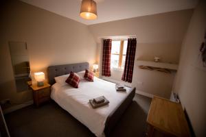 a bedroom with a bed with two pillows and a window at The Townhouse in Fort William