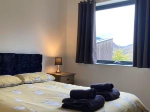 a bedroom with a bed with two towels on it at Svarga Mountain View in Kinlochleven