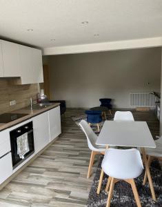 cocina con mesa y sillas en una habitación en l'ECURIE pour 6 personnes, en Lebétain