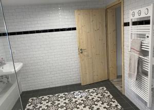 baño con puerta de madera y lavamanos en l'ECURIE pour 6 personnes, en Lebétain