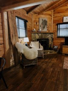 a living room with two chairs and a fireplace at Sylvan Valley Lodge and Cellars in Sautee Nacoochee