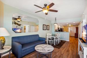 ein Wohnzimmer mit einem blauen Sofa und einem Tisch in der Unterkunft Sunset Vistas 501W in St Pete Beach