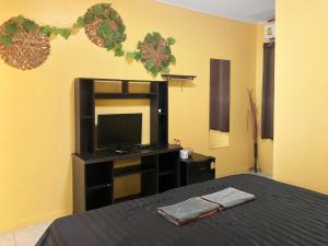 um quarto com uma cama, uma televisão e uma mesa em Blue Beach Resort em Baanphakrimlay 