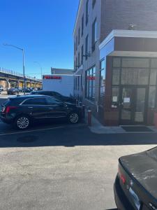 un coche negro aparcado en un estacionamiento junto a un edificio en Atlantic Motor Inn, en Brooklyn