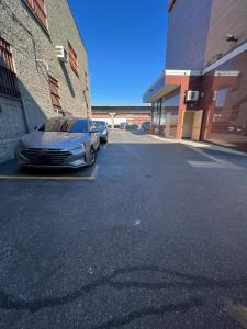 un coche aparcado en un aparcamiento al lado de un edificio en Atlantic Motor Inn, en Brooklyn