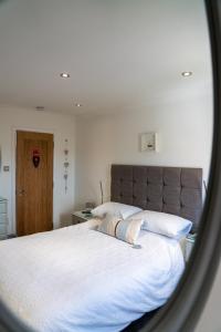 a bedroom with a large bed with white sheets at Tor View B&B in Padstow