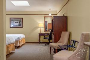 a hotel room with a bed and a chair and a desk at Hotel Seville in Harrison