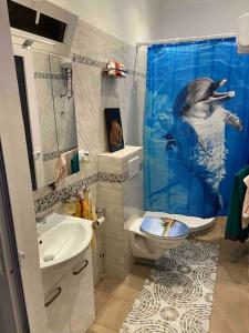 a bathroom with a dolphin shower curtain and a sink at Appartement Altona in Lomé +34 photos