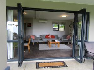 un soggiorno con divano e tavolo di Cornwallis Palms ad Auckland