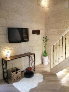 sala de estar con TV en una pared de piedra en Palazzo Emy, en Lecce