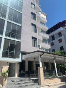 een groot gebouw met een patio ervoor bij Hotel Ergi in Durrës