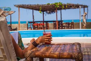 una mujer sentada en una mesa con una bebida en Blue Ocean en Máncora