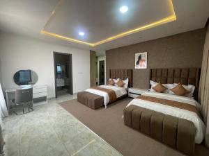 a hotel room with two beds and a television at Romel Terraces in Lagos