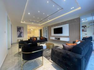 a living room with couches and a flat screen tv at Romel Terraces in Lagos