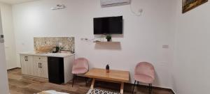 a kitchen with two pink chairs and a table at Astra Hermon Zimmer in Majdal Shams +17 photos