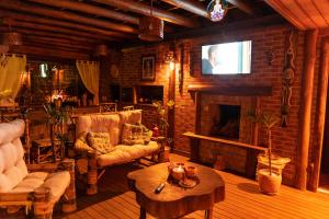 a living room with a fireplace and a tv at ॐ Rosa Astral ॐ in Praia do Rosa