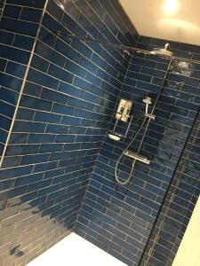 a bathroom with a blue tiled wall with a shower at St Mary's Cottage in Boston Spa +18 photos