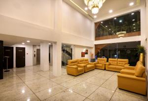 a lobby with couches and chairs in a building at Mango Hill Central Chennai in Chennai