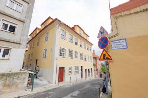 a street with a yellow building on the side of a road at New Lisbon Center Apartment in Lisbon
