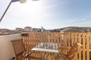 a table and chairs on a balcony with a view at Cabana & Grand appartement cosy - Parking & Balcon in Villefranche-sur-Saône