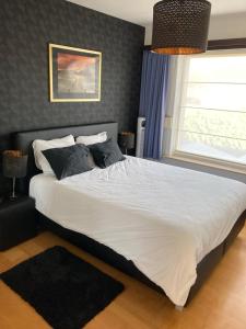una camera da letto con un grande letto bianco con una finestra di Crea Els a Westerlo