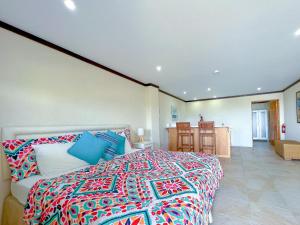 a bedroom with a large bed with a colorful blanket at Santosha Barbados in Saint Andrew