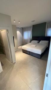 a bedroom with a large bed and a green wall at Vacation Apartment By The Beach in Bat Yam