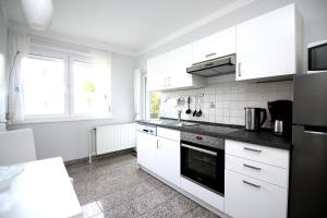 a kitchen with white cabinets and a stove top oven at Am Apfelgarten-2 Apartments mit eigenem Parkplatz-Flörekeweg in Lüneburg