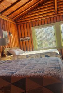 a bedroom with two beds and a window at High Falls Motel & Cabins in Wawa