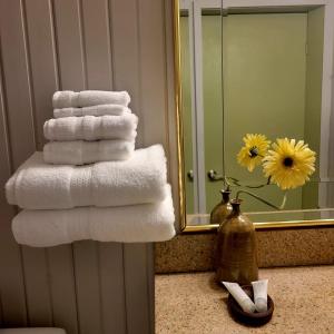 a stack of towels in a bathroom with a mirror at High Falls Motel & Cabins in Wawa