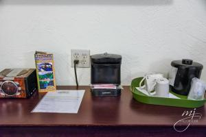 a wooden table with a coffee maker on a table at Hotel Seville in Harrison