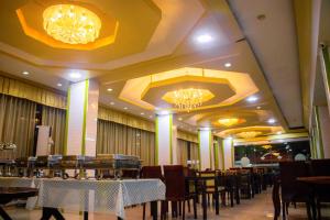 a dining room with tables and chairs and chandeliers at Visiting Card Hotel & Resort in Bangkok