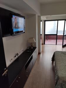 a hotel room with a television on the wall at Depto 2 amb- Punta Mogotes- ideal para altos in Mar del Plata