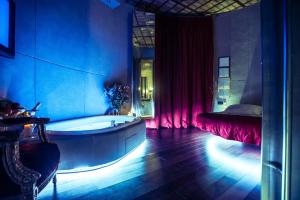 - une salle de bains bleue pourvue d'une baignoire et d'un lit dans l'établissement MDM Guesthouse, à Rome