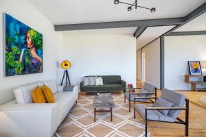 - un salon avec un canapé blanc et des chaises dans l'établissement Brand New Luxury 4-Bed with Riverside Views & AC, à Lisbonne