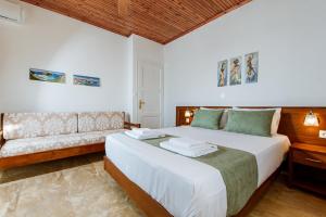 ein Schlafzimmer mit einem großen Bett und einem Sofa in der Unterkunft Evelina's House in Platanias