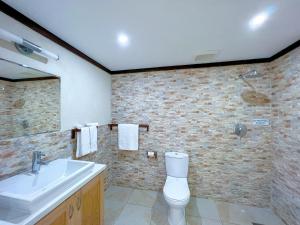 a bathroom with a sink and a toilet at Santosha Barbados in Saint Andrew