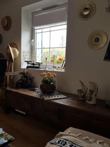 Una habitación con una mesa con un jarrón de flores. en Chaumière avec sa toiture recouverte de chaume !!!, en Donnemain-Saint-Mamès