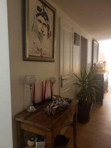Habitación con una mesa de madera y una pintura en la pared. en Chaumière avec sa toiture recouverte de chaume !!!, en Donnemain-Saint-Mamès